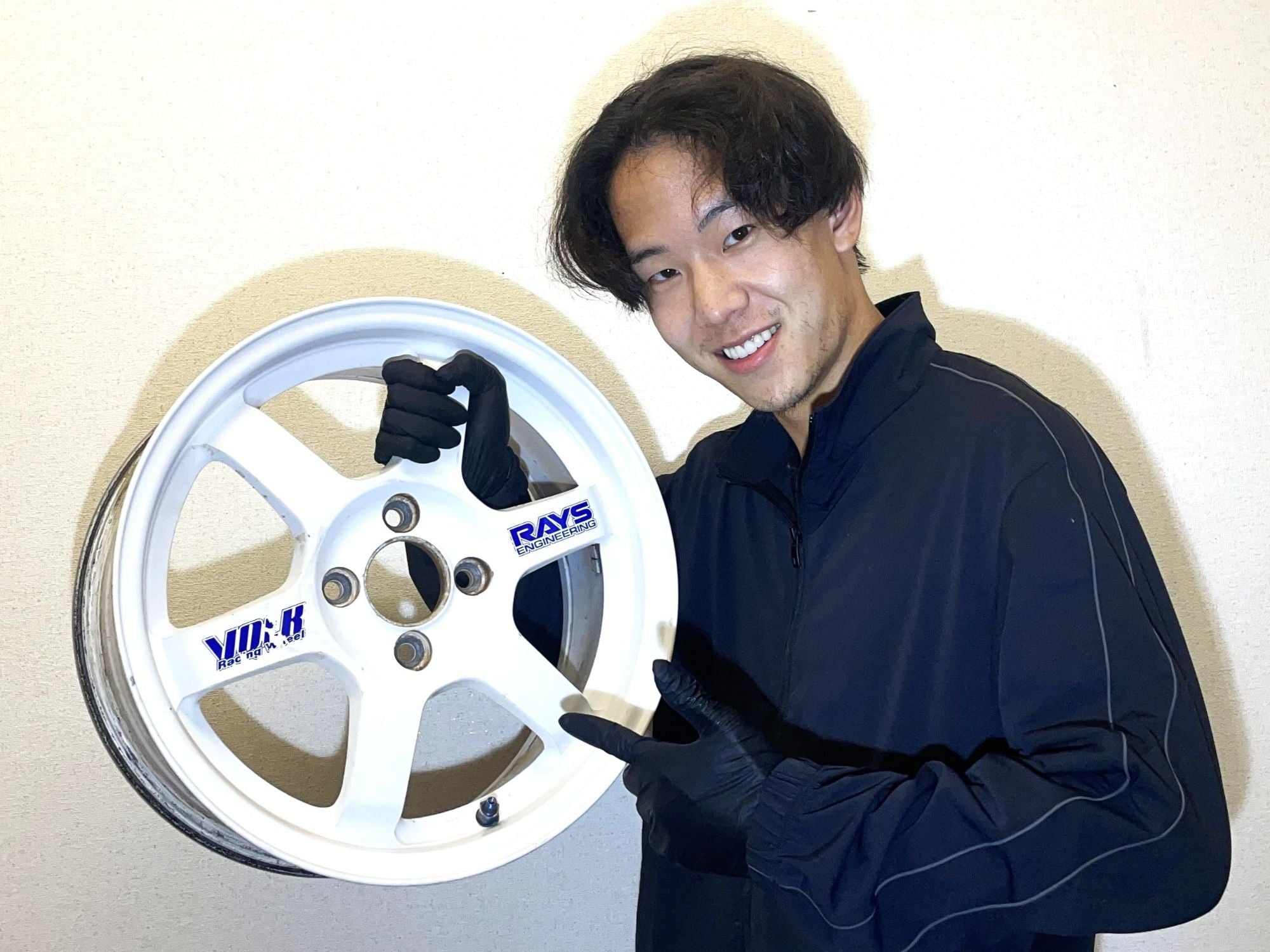 OPUS staff holding a JDM wheel sourced from a Japanese auction