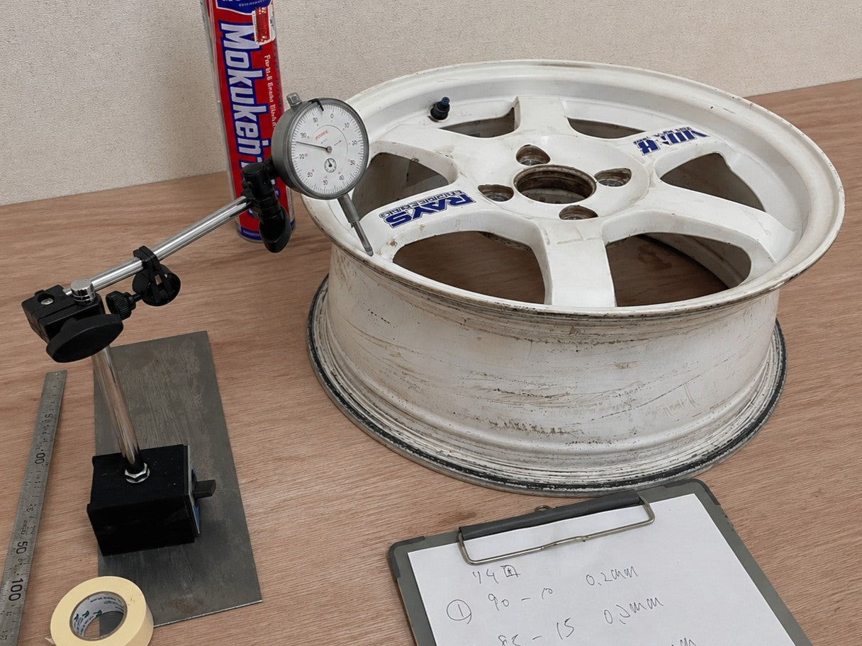 Wheel runout being measured with a dial gauge during physical inspection