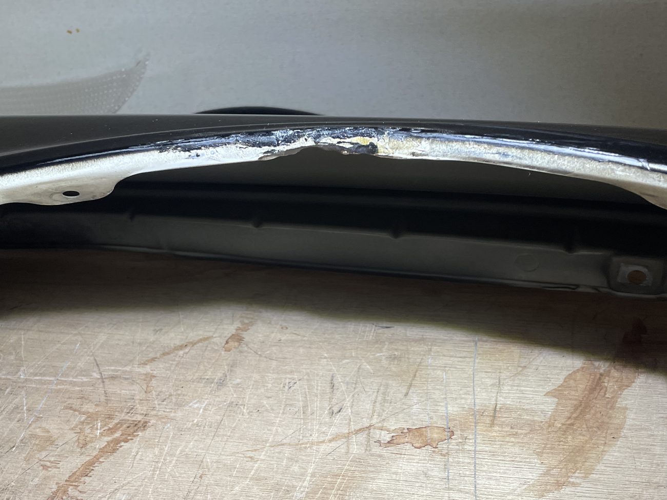 A chipped edge and peeling paint on a fender