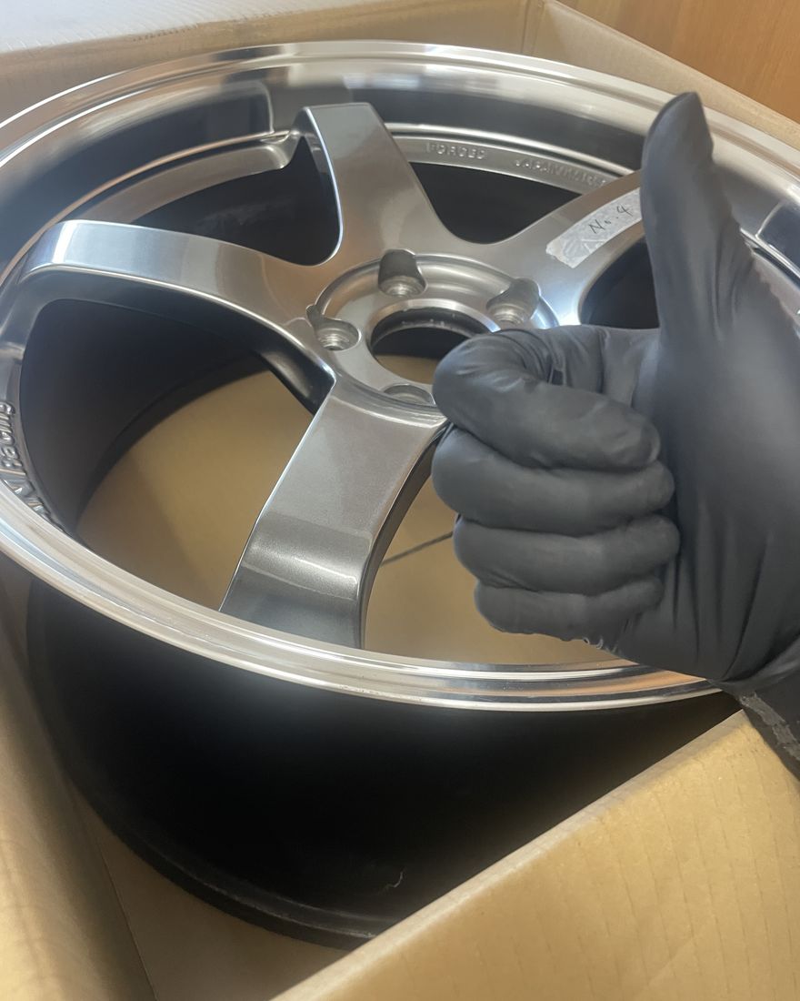 A gloved thumbs-up, showing a wheel in its box