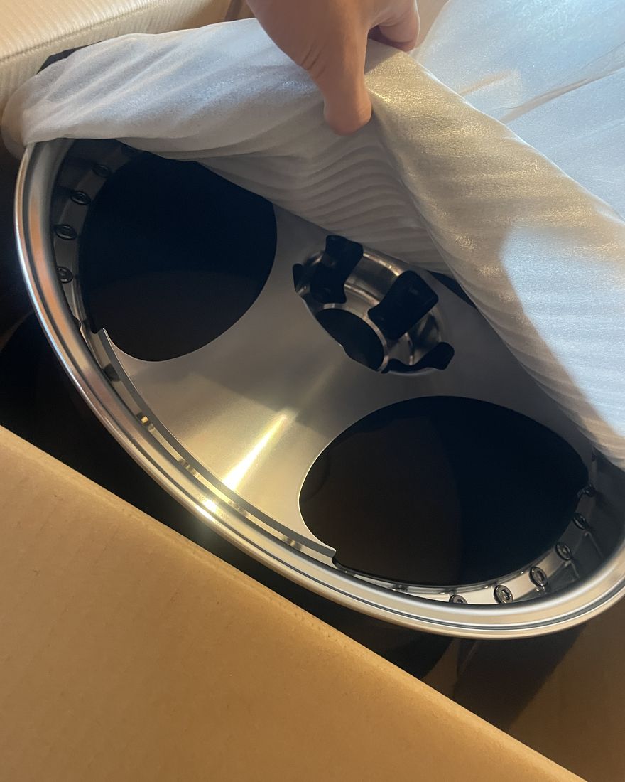 A wheel wrapped in packing material, in a box